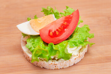 Rice Cake Sandwich with Tomato, Lettuce and Egg on Bamboo Cutting Board. Easy Breakfast. Diet Food. Quick and Healthy Sandwiches. Crispbread with Tasty Filling. Healthy Dietary Snack