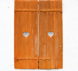 Vintage wooden windows on a white wall with hearts.