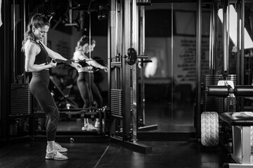 Obraz na płótnie Canvas Woman Doing Exercise on a Machine in a Gym