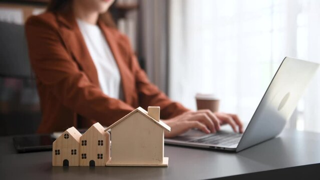 Salesman Hands On House Model , Small Toy House Small Mortgage Property insurance and concepts real estate in office.