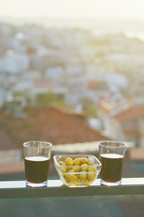 Two glasses of red wine and green olives with view to the roofs of Uskudar district on Asian side of Istanbul, Turkey