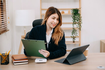 Woman freelancer is working her job on computer tablet and laptop Doing accounting analysis report real estate investment data, Financial at office
