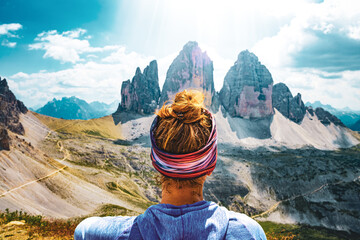 Young athletic woman enjoys view on Tre Cime mountain range in the morning. Tre Cime, Dolomites, South Tirol, Italy, Europe.