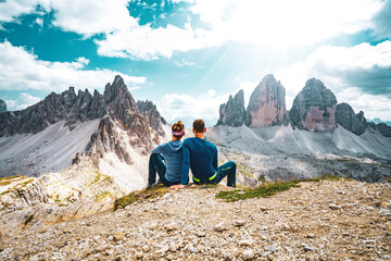 Young athletic couple enjoys scenic view on Monte Paterno and Tre Cime in the afternoon. Tre Cime, Dolomites, South Tirol, Italy, Europe.