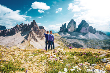 Young athletic couple enjoys summit of Sasso di Sesto in the afternoon. Tre Cime, Dolomites, South...