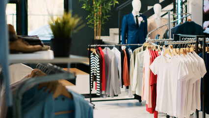 Interior of clothing store with stylish merchandise on racks, fashionable brand design and casual...