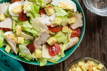 Appetizing Caesar salad in a plate on a wooden table