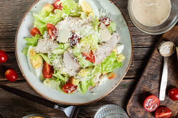 Appetizing Caesar salad in a plate on a wooden table