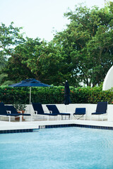 luxury resort, vacation and holiday concept, sunbeds and outdoor chairs near umbrellas around green...