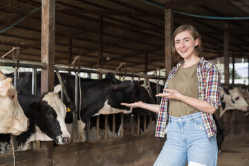agriculture industry, dairy farming. Happy dairy farmer female working in cowshed on dairy farm