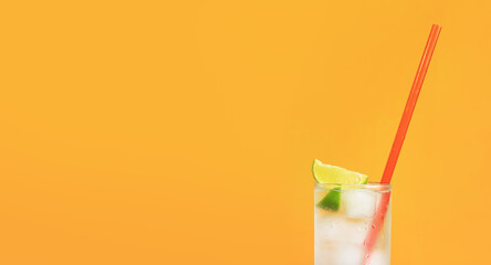 Iced tea with ice and lime on an orange background. Summer cocktail with cold drink. Copy space