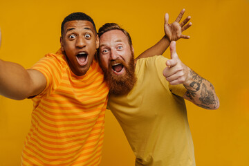 Selfie of two excited men laughing while gesturing together isolated