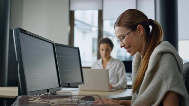 Smiling it woman programming software in office. Startup engineer checking code