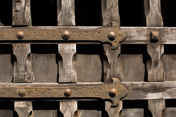 Medieval wooden door with decorated finges, vintage background.