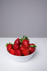 Fresh strawberries on a white plate, on a white background