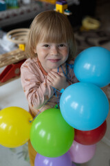 Fototapeta na wymiar Happy child on his birthday rejoice inflatable balls