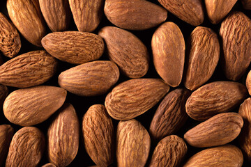 Background of large raw almonds close up. View from above.