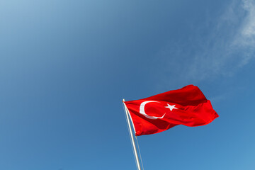 Turkish flag waving in the wind against a blue sky