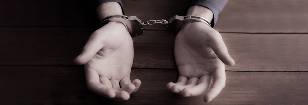 man hand handcuffs on table