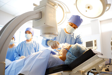 A team of doctors and surgeons operate on a patient inside the operating room.