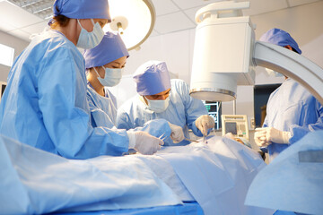 A team of doctors and surgeons operate on a patient inside the operating room.