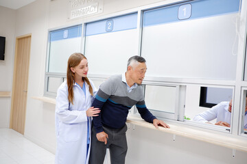 A female doctor supported an old male patient to take the medicine.