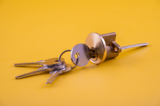 Cylinder mortice lock for doors with keys in brass alloy metal isolated on a yellow background