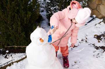 Full length portrait of lovely little child girl 5 years old, in pink down jacket and fluffy...