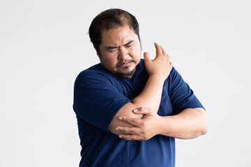 Middle aged man suffering from elbow joint pain, concept of tennis elbow or golfer’s elbow...