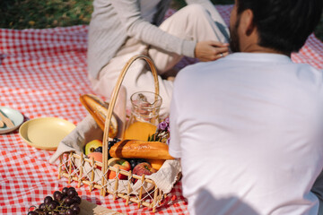 In love couple enjoying picnic time in park outdoors Picnic. happy couple relaxing together with picnic Basket