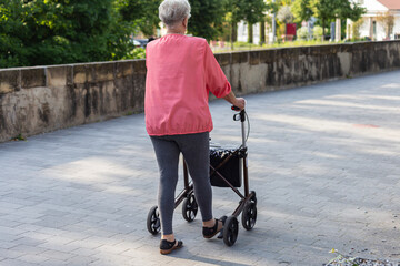 senior with rollator and crutch in springtime park