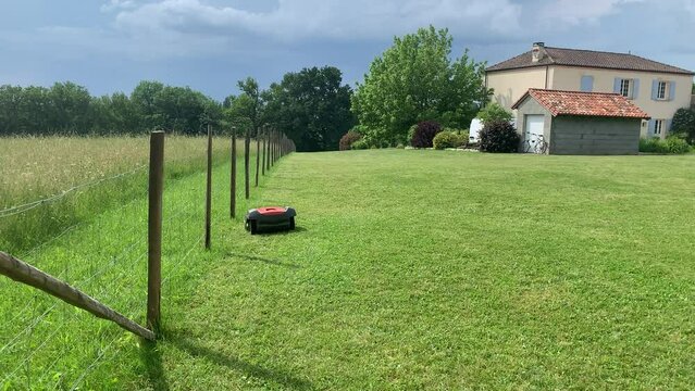robotic lawn mower cutting grass, turns and continues mowing.