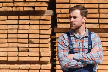 Carpenter in uniform check boards on sawmill