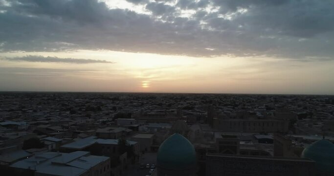 A drone flies around the famous memorial complex Kalyan Poi Kalon Complex and Poi Kalon Minaret, Poi Kalan or Po-i-Kalyan in Bukhara at dawn