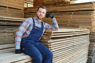 Male Worker folds boards. Sawmill. Wood harvesting process