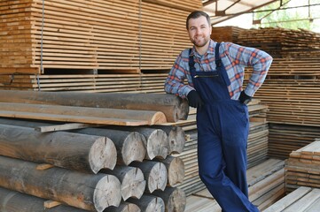 Carpenter in uniform check boards on sawmill