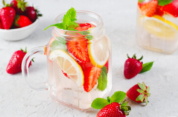 Strawberry Infused Water, Refreshing Cocktail, Lemonade, Detox Iced Drink with Fresh Strawberry, Lemon and Mint on Bright Background
