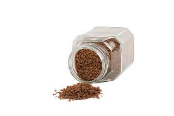 Instant coffee poured from a glass jar of coffee on a white background.