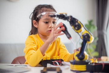 Fototapeta na wymiar STEM education concept. Asian students learn at home by coding robot arms in STEM, mathematics engineering science technology computer code in robotics for kids' concepts.