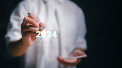 Happy new year 2024 hand write on a virtual screen 2024. New Goals, Plans, and Numbers for Next...