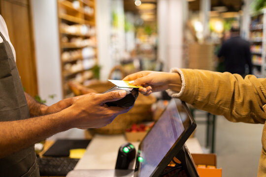 Crop customer paying with credit card in shop