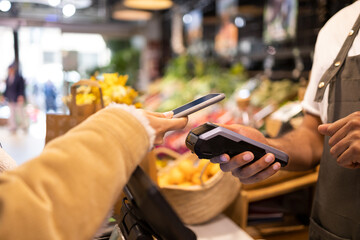 Anonymous customer paying with smartphone for purchases