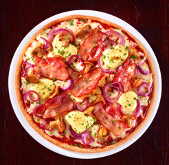 Pizza mit Bacon und roten Zwiebelringen und Champignons plus Kraeuter