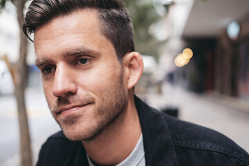 Close up portrait of a smiling man, street on the background 