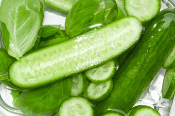 Fresh green cucumbers sliced in water.