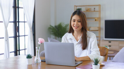 Working lifestyle at home concept, Women typing data on laptop while working at modern home office
