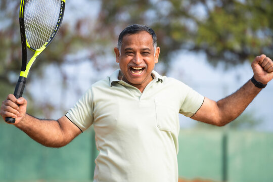 Indian angry frustrated senior man after losing or defeating tennis match - concept of competition, challenges and tournament