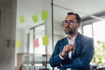 Businessman thinking and taking notes in his office.