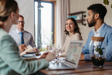 Young colleagues having casual discussion during meeting in office.