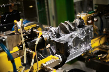 Illuminated car engine on test stand in production plant shop